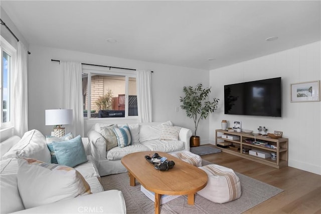 living area with wood finished floors, plenty of natural light, and baseboards