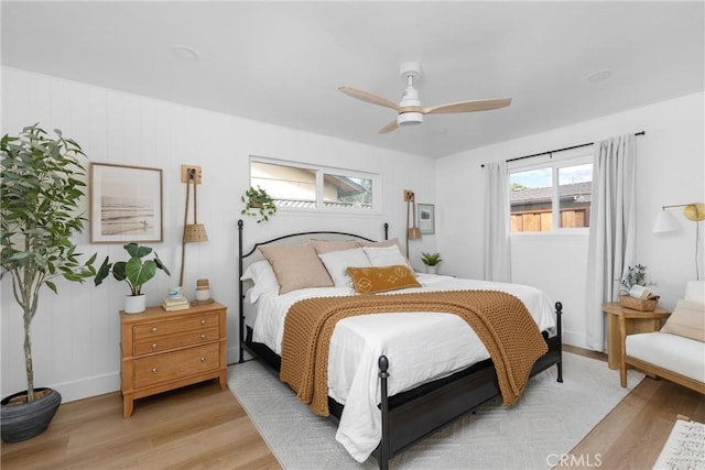 bedroom featuring light wood-style floors, ceiling fan, and baseboards