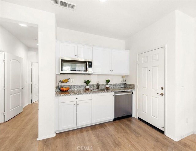 29628 Dotted Mint, Winchester, CA 92596 - kitchen featuring stainless steel appliances, a sink, light wood-style floors, white cabinetry, and light stone counters