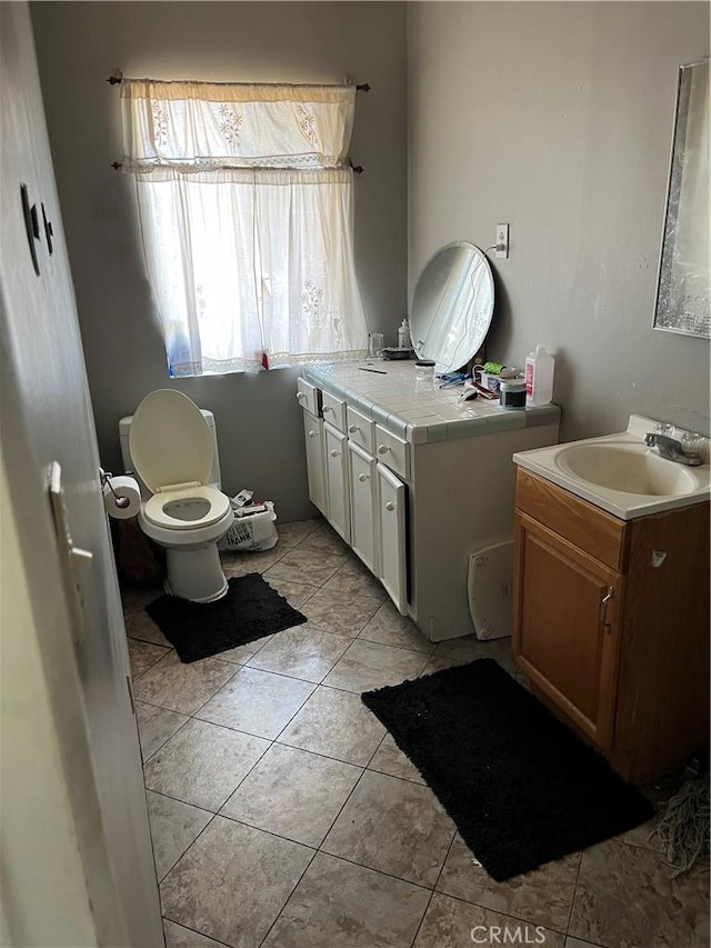 bathroom with vanity, toilet, and tile patterned floors