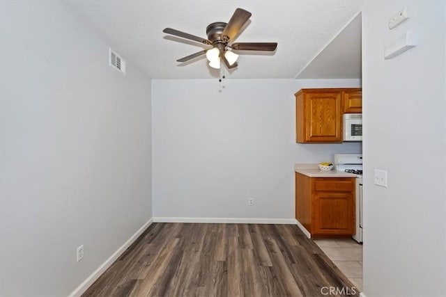 8990 19th St Unit 383, Rancho Cucamonga, CA 91701 - kitchen with white appliances, a ceiling fan, brown cabinets, light wood-style flooring, and light countertops