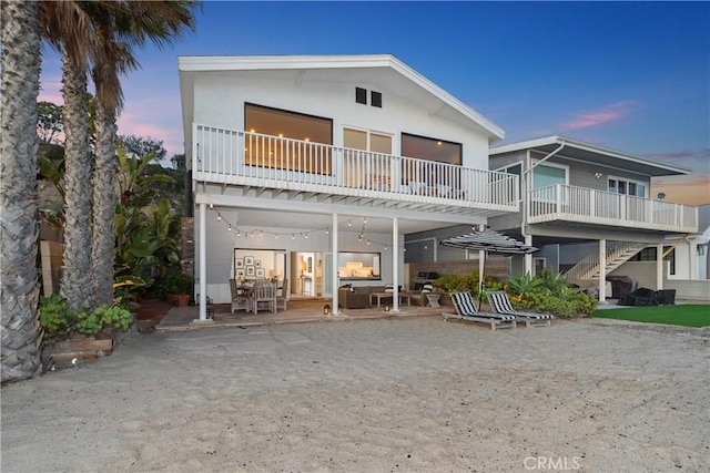35581 Beach Rd, Dana Point, CA 92624 - back of house at dusk featuring a patio area, stairs, and a balcony