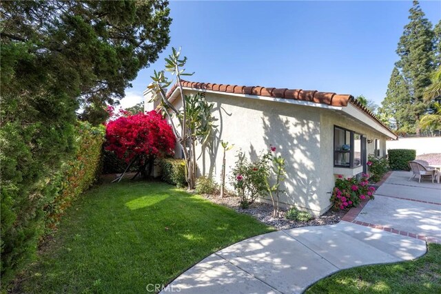 5110 Via Donaldo, Yorba Linda, CA 92886 - view of home's exterior featuring a patio area, a lawn, stucco siding, and a tiled roof