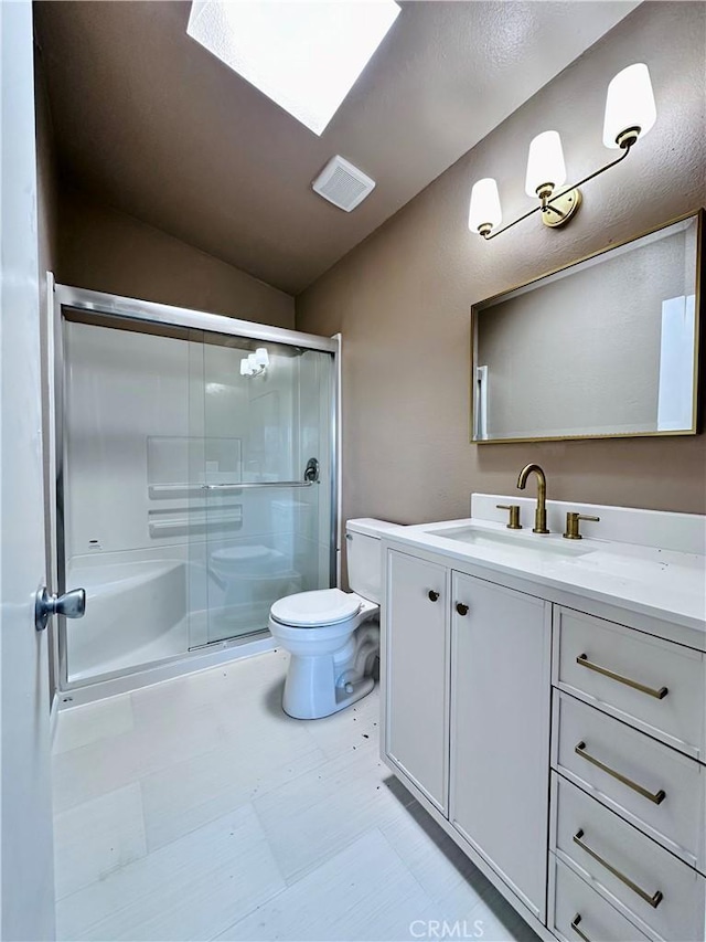 bathroom featuring tile patterned floors, toilet, a shower stall, vanity, and lofted ceiling