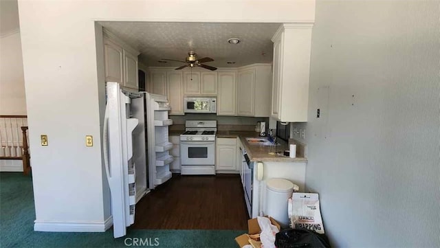 kitchen with white appliances, a ceiling fan, white cabinetry, and a sink