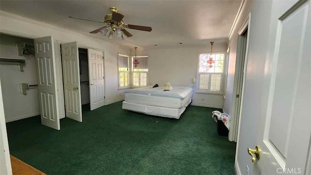 bedroom with dark carpet, multiple windows, and baseboards