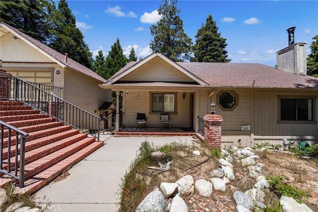 179 Chippewa Ln, Lake Arrowhead, CA 92352 - view of front of house with covered porch, a chimney, and roof with shingles