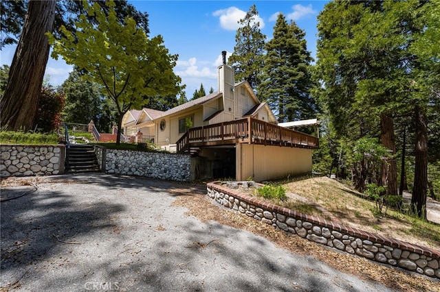 179 Chippewa Ln, Lake Arrowhead, CA 92352 - view of side of home featuring stairway, a wooden deck, and a chimney