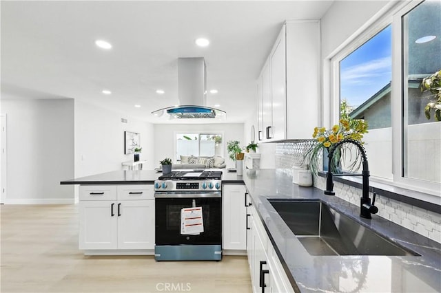 1608 E Helmick St, Carson, CA 90746 - kitchen with stainless steel range with gas cooktop, a sink, island range hood, a peninsula, and tasteful backsplash