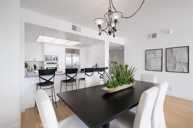 850 E Ocean Blvd Unit 602, Long Beach, CA 90802 - dining area featuring a chandelier and light wood finished floors