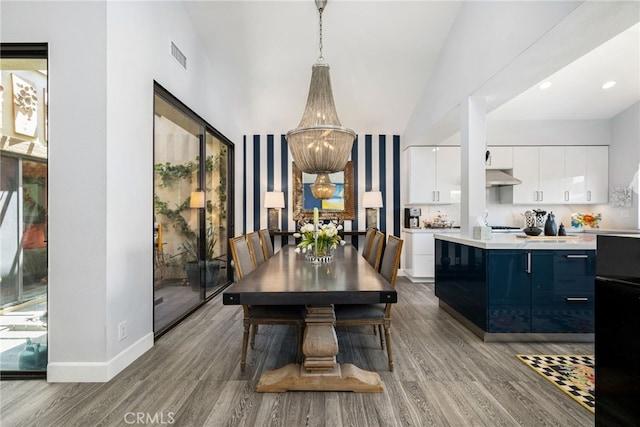 dining space featuring wood finished floors, baseboards, and lofted ceiling