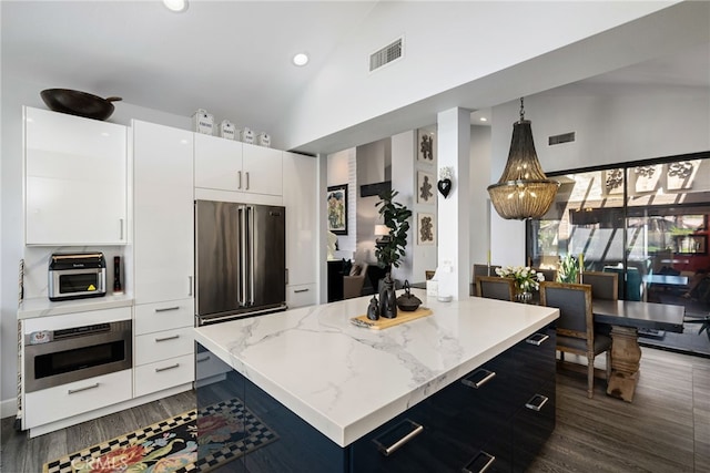kitchen featuring oven, high end refrigerator, high vaulted ceiling, dark wood-type flooring, and recessed lighting
