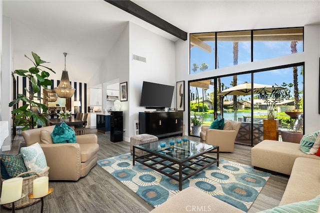 living room featuring high vaulted ceiling, wood finished floors, baseboards, and beamed ceiling