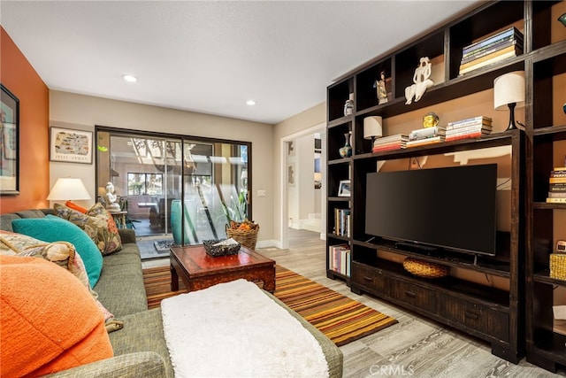 living area featuring wood finished floors, baseboards, and recessed lighting