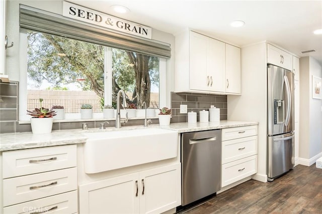 17301 Elsinore Cir, Huntington Beach, CA 92647 - kitchen with appliances with stainless steel finishes, a sink, backsplash, white cabinets, and dark wood finished floors