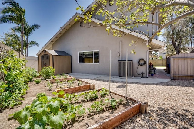 17301 Elsinore Cir, Huntington Beach, CA 92647 - rear view of property featuring a storage shed, a vegetable garden, an outdoor structure, a patio area, and stucco siding