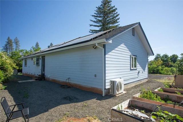 6151 N Libby Rd, Paradise, CA 95969 - view of side of home with a garden, ac unit, roof mounted solar panels, and entry steps