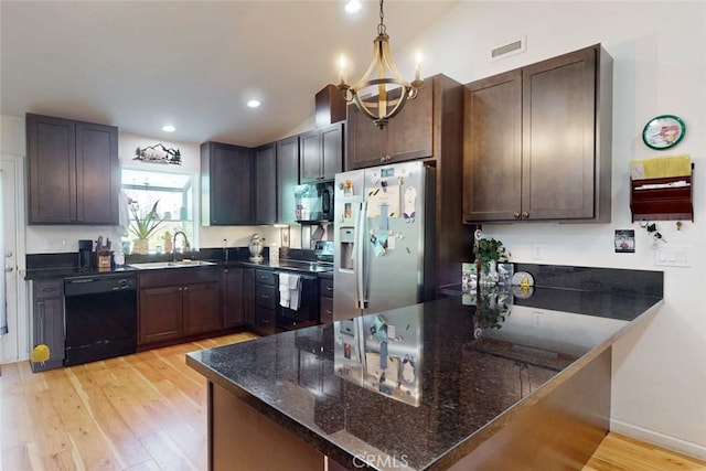 6151 N Libby Rd, Paradise, CA 95969 - kitchen with black appliances, light wood-style flooring, a sink, a peninsula, and dark stone counters