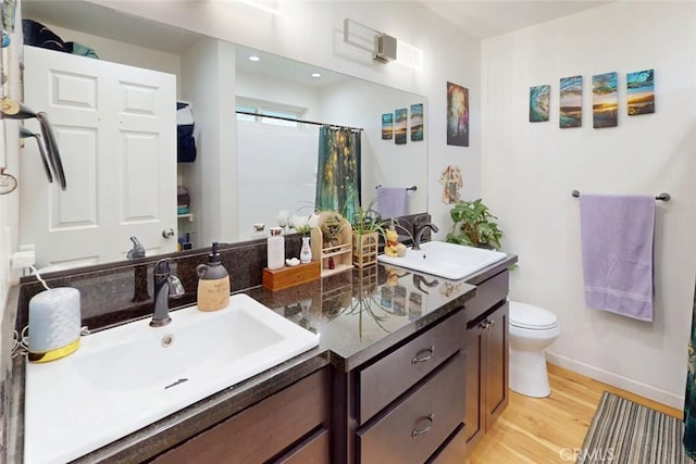 6151 N Libby Rd, Paradise, CA 95969 - bathroom featuring wood finished floors, toilet, baseboards, double vanity, and a shower with shower curtain