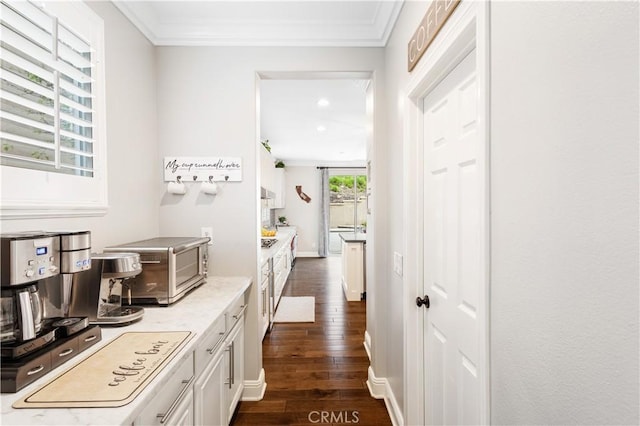 hall with dark wood finished floors, ornamental molding, and recessed lighting