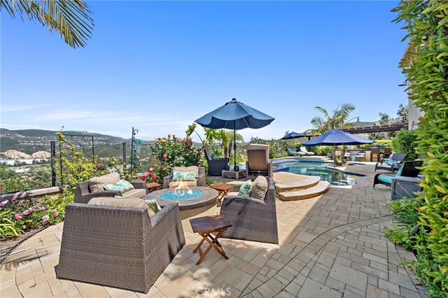 7051 Sitio Caliente, Carlsbad, CA 92009 - view of patio / terrace with a fire pit, an outdoor pool, and a mountain view