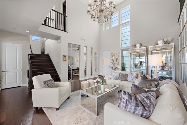 7051 Sitio Caliente, Carlsbad, CA 92009 - living area with stairway, dark wood finished floors, a towering ceiling, a chandelier, and baseboards