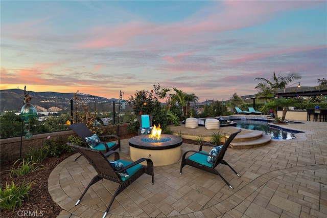 7051 Sitio Caliente, Carlsbad, CA 92009 - patio terrace at dusk featuring a fire pit, a patio area, and a mountain view