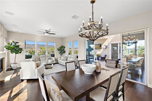 7051 Sitio Caliente, Carlsbad, CA 92009 - dining space featuring a chandelier, dark wood-style flooring, a ceiling fan, and a premium fireplace
