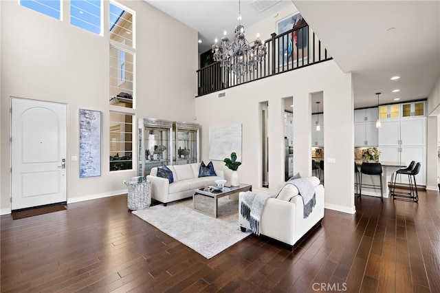 7051 Sitio Caliente, Carlsbad, CA 92009 - living room featuring a towering ceiling, a chandelier, and dark wood finished floors