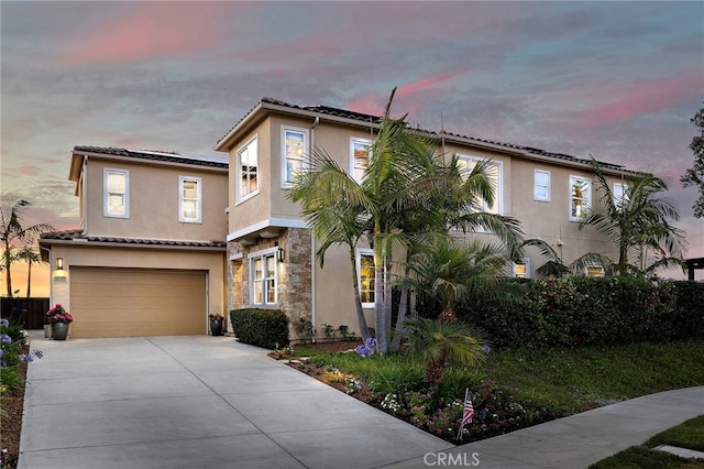 7051 Sitio Caliente, Carlsbad, CA 92009 - view of front facade featuring an attached garage, stucco siding, stone siding, driveway, and a tiled roof