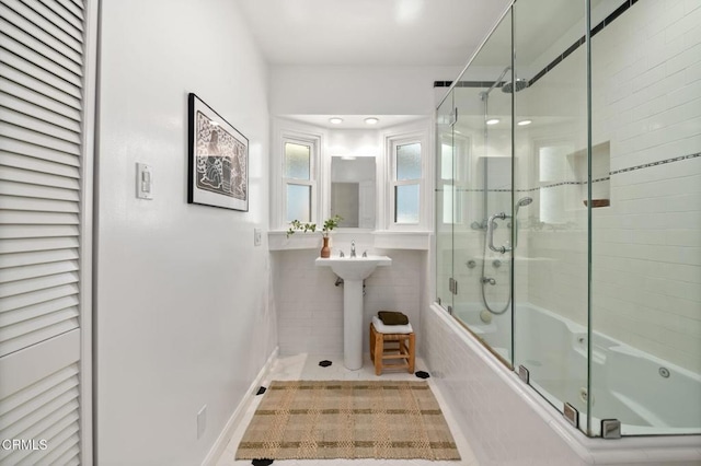 full bath with bath / shower combo with glass door and tile patterned flooring