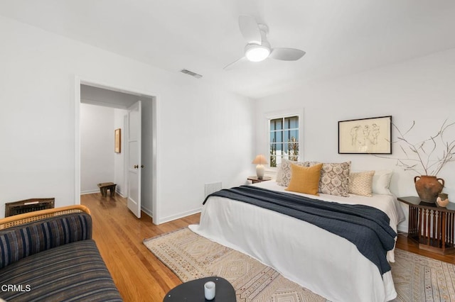 bedroom featuring wood finished floors, a ceiling fan, and baseboards