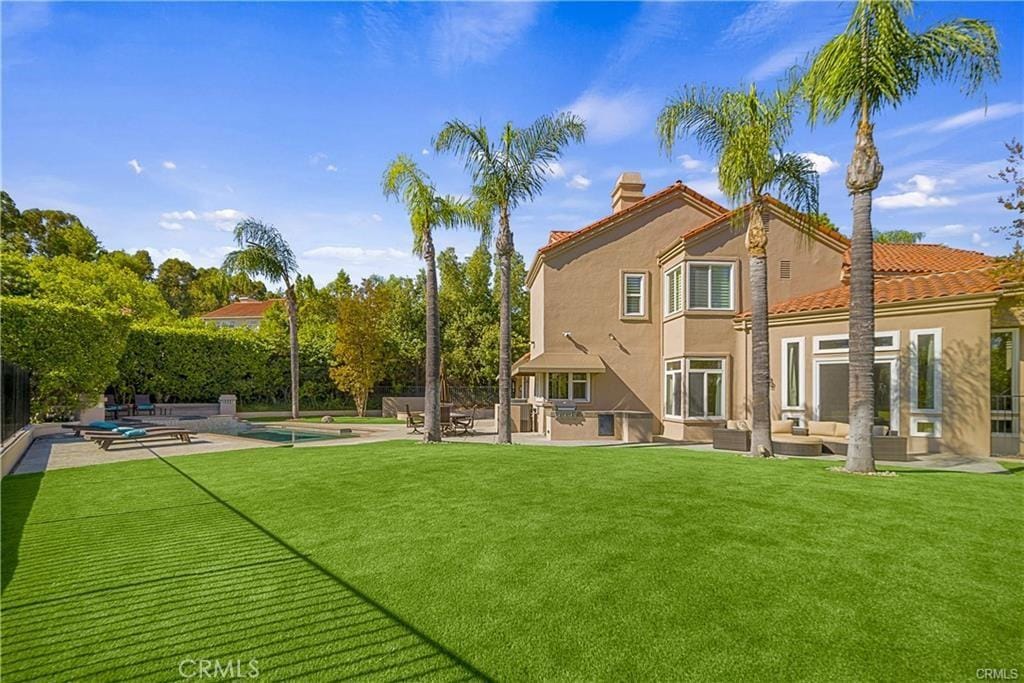 rear view of house featuring a patio, outdoor lounge area, stucco siding, and a swimming pool