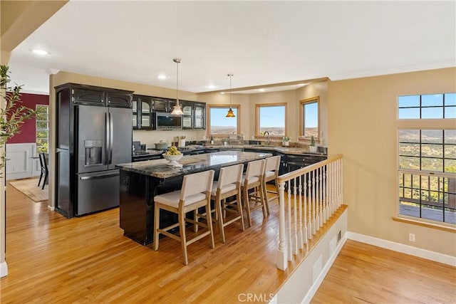 10885 San Marcos Rd, Atascadero, CA 93422 - kitchen featuring stainless steel appliances, light wood-style floors, recessed lighting, a center island, and a breakfast bar