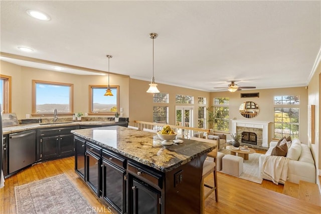 10885 San Marcos Rd, Atascadero, CA 93422 - kitchen featuring stainless steel dishwasher, a sink, a breakfast bar, ceiling fan, and dark cabinetry