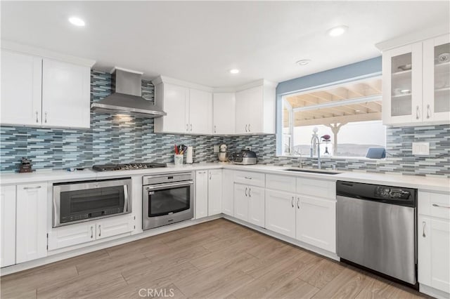36755 Tierra Subida Ave, Palmdale, CA 93551 - kitchen with stainless steel appliances, wall chimney exhaust hood, a sink, light countertops, and white cabinetry