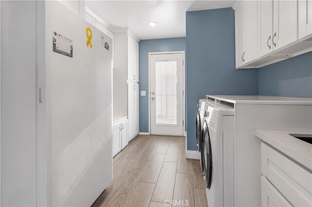 36755 Tierra Subida Ave, Palmdale, CA 93551 - laundry area featuring cabinet space, separate washer and dryer, light wood-style floors, and baseboards