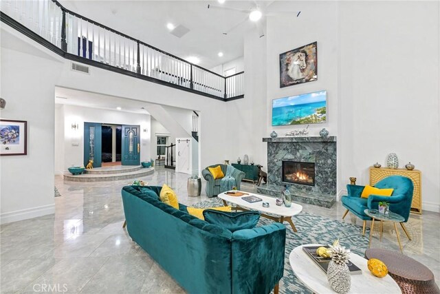 22252 Monte Rancho Dr, Temecula, CA 92590 - living area featuring baseboards, a towering ceiling, a high end fireplace, a ceiling fan, and marble tiled flooring