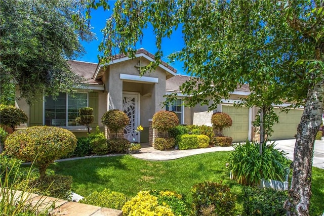view of front of house with stucco siding, a garage, a front yard, and driveway