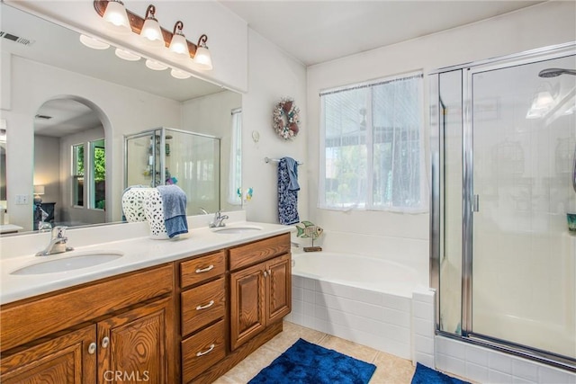 full bath featuring tile patterned flooring, a stall shower, double vanity, a garden tub, and ensuite bath