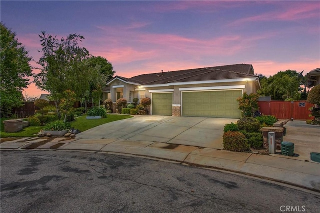 single story home with concrete driveway, a garage, fence, and stucco siding