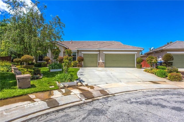 view of front of property featuring stucco siding, an attached garage, concrete driveway, and a tile roof