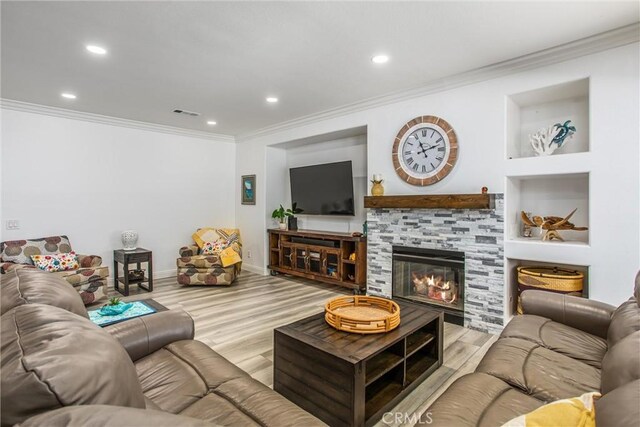 living room with crown molding, wood finished floors, recessed lighting, a glass covered fireplace, and baseboards