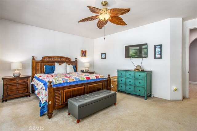carpeted bedroom featuring a ceiling fan and arched walkways
