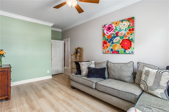 living area featuring ceiling fan, ornamental molding, light wood finished floors, and baseboards
