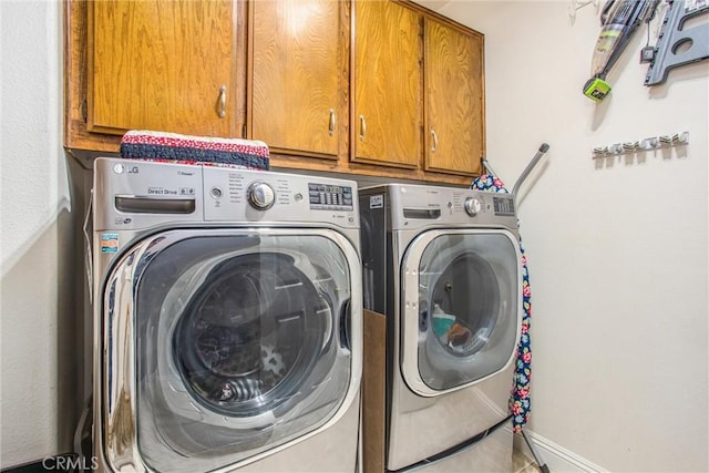 clothes washing area with cabinet space and washing machine and clothes dryer