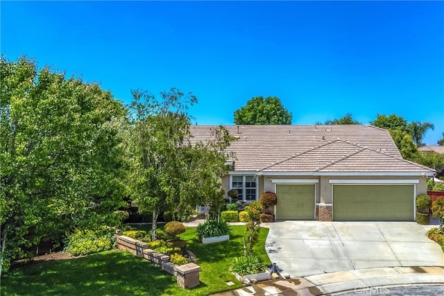 view of front of property with a garage, stucco siding, concrete driveway, and a front lawn