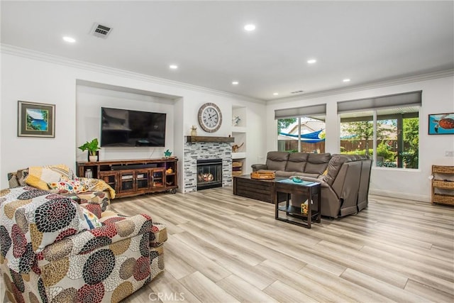 living area with ornamental molding, light wood-style flooring, recessed lighting, baseboards, and a glass covered fireplace
