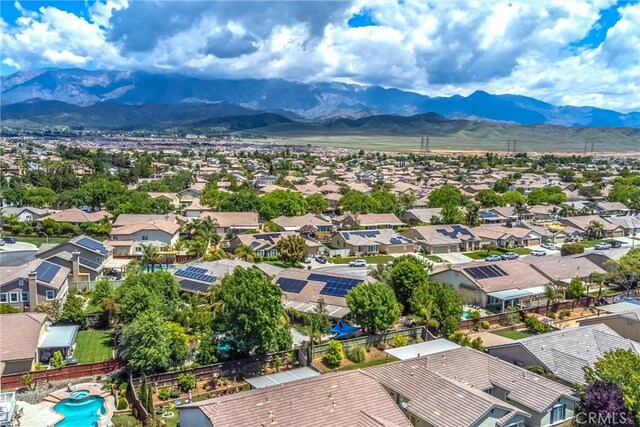 aerial view of residential area featuring a mountain backdrop and a pool area