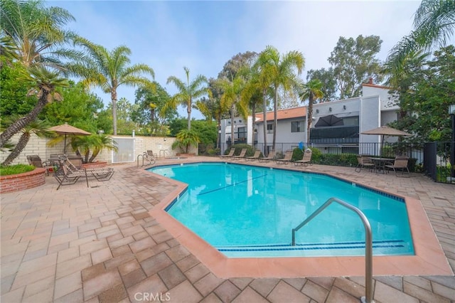 community pool featuring a patio and fence